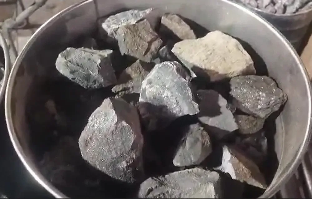 Металл ыдыстағы тастар, көмір және минералдар бөліктері.