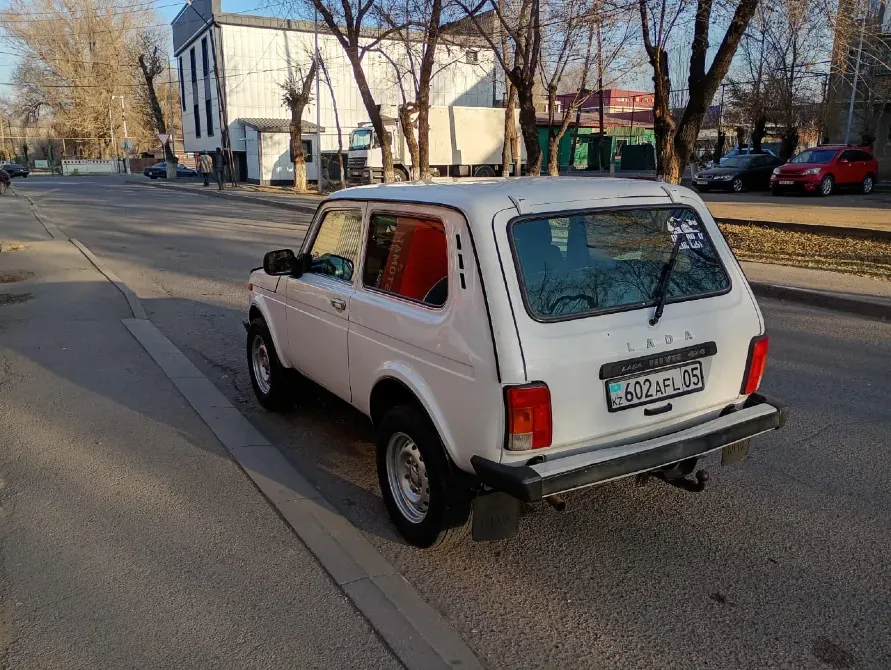 Задний вид белого автомобиля Лада на улице