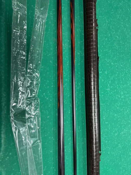 Два бильярдных кия и упаковка рядом с чехлом