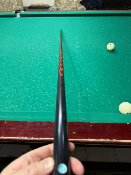 Бильярдный кий в руках человека с шариками на столе
