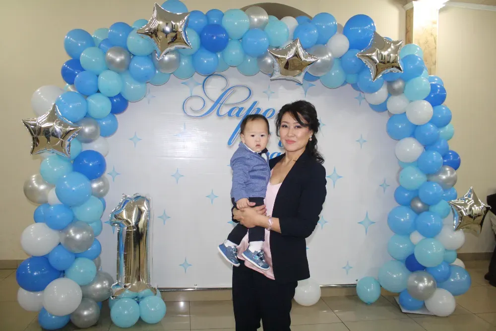 Женщина с ребенком на фоне украшений из шаров