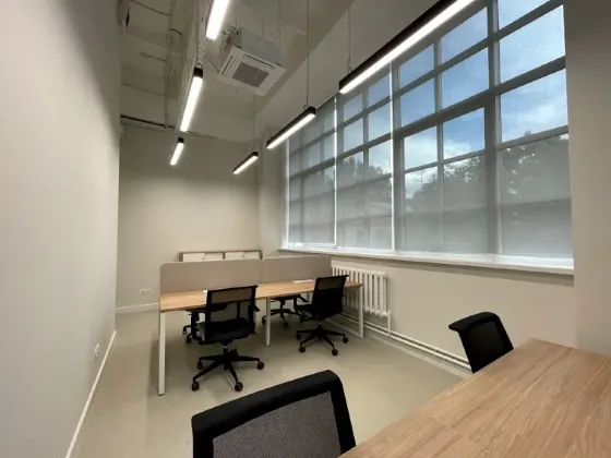 Заманауи офис бірнеше жұмыс орындарымен және үлкен терезелерімен