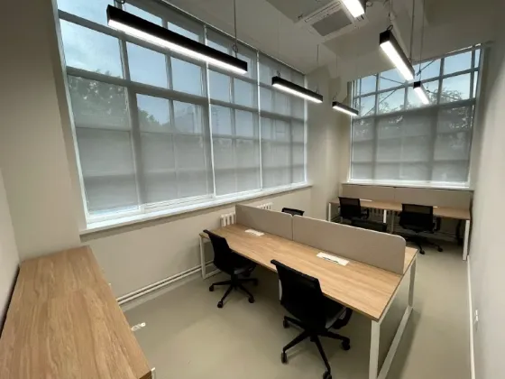 Заманауи офис бірнеше жұмыс орындарымен және үлкен терезелерімен