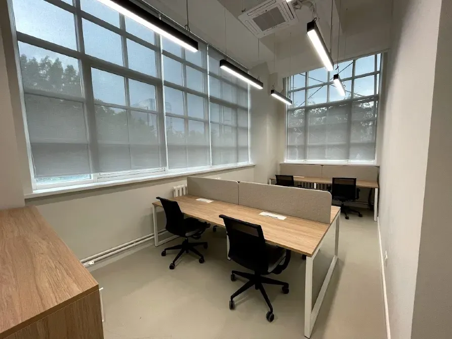 Удобные рабочие места в офисе с окнами и светлым интерьером