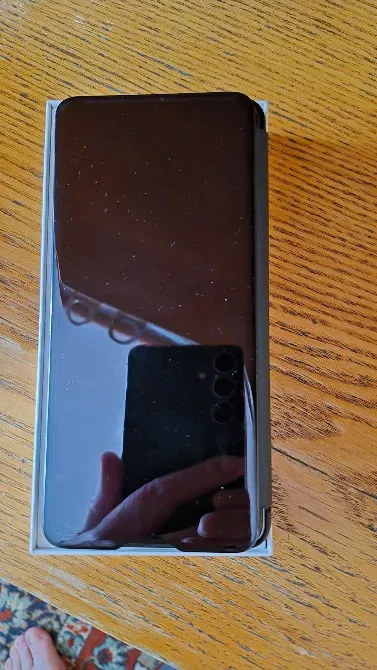 Передняя сторона телефона Samsung в упаковке с отражением