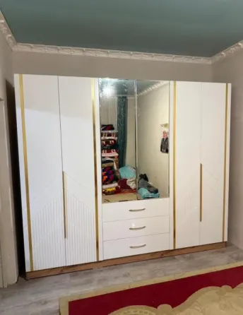 Айнамен және алтын декорациялық элементтерімен шкафта бөлмеде. Оның бірнеше есігі мен шығатын жәшіктері бар.