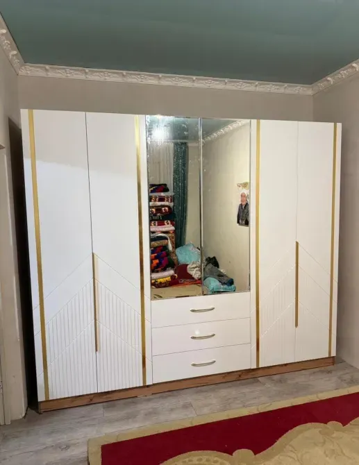 Айнамен және алтын декорациялық элементтерімен шкафта бөлмеде. Оның бірнеше есігі мен шығатын жәшіктері бар.