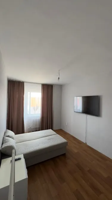 Диван мен терезелері бар жатын бөлме