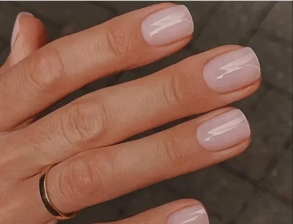 Ногти с легким прозрачным покрытием и обручальным кольцом на пальце