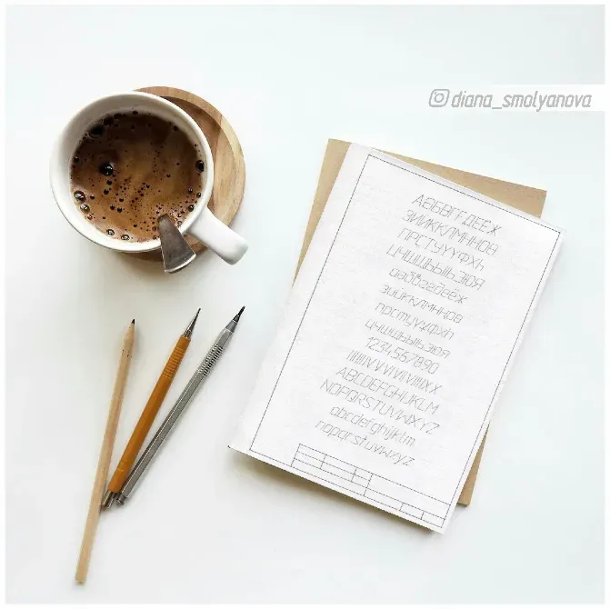 Ыстық сусыны бар кружка және ақ фондағы сызбалары бар блокноттар