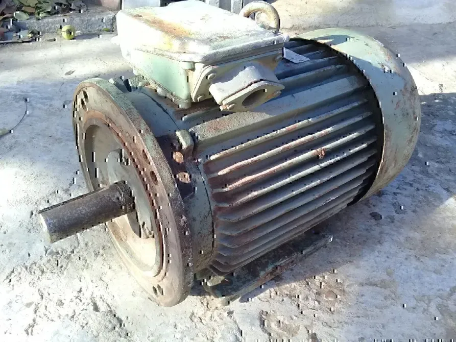 Старый электрический мотор на бетонном полу