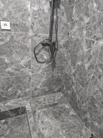 Современная душевая кабина с серыми мраморными стенами и полом