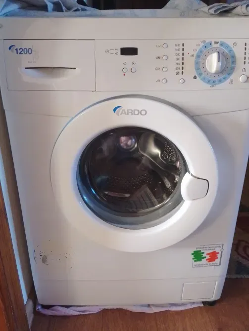 Стиральная машина Ardo с фронтальной загрузкой, белого цвета, расположенная в помещении