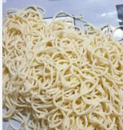 Тонкие спагетти, уложенные в беспорядочную массу на столе