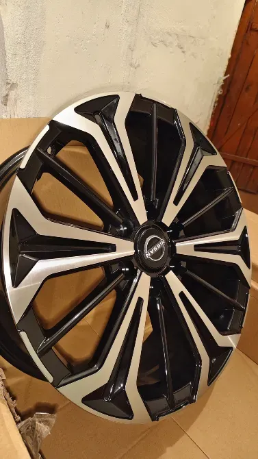 Колесо с оттенком черного и хрома, вид спереди, установленное на картонной поверхности