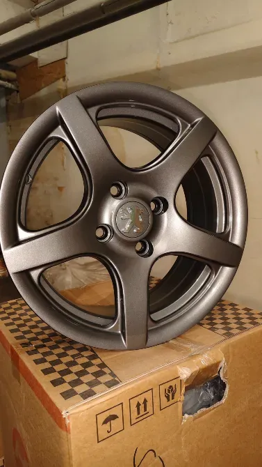 Диск автомобиля с пятью спицами темного цвета, установленный на коробке