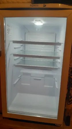 Бос тоңазытқыш мөлдір есіктермен және металл сөрелермен