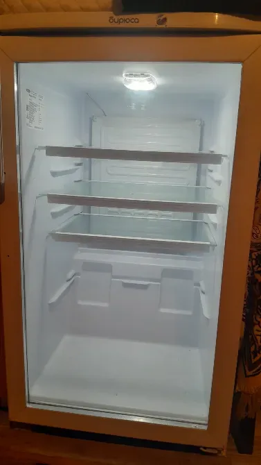 Внутренний вид пустого холодильника с освещением и полками для продуктов