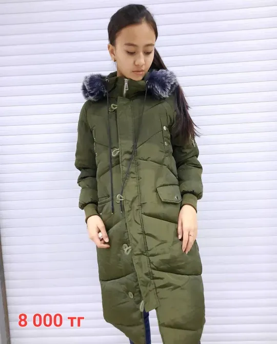 Зелёная зимняя куртка с меховым капюшоном на девушке