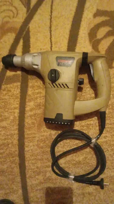 Электрический перфоратор с шнуром и функцией регулировки на поверхности ковра