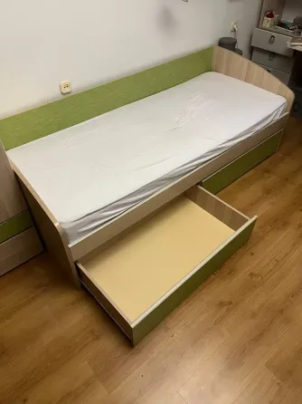 Бір адамдық төсек, шығатын жәшігі бар және жасыл қаптау