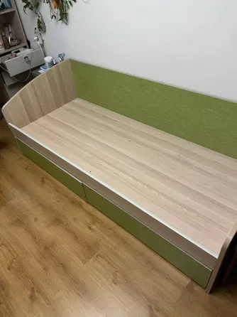 Бір адамдық төсек, шығатын жәшігі бар және жасыл қаптау