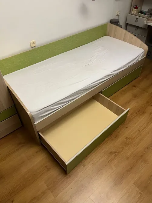 Бір адамдық төсек, шығатын жәшігі бар және жасыл қаптау