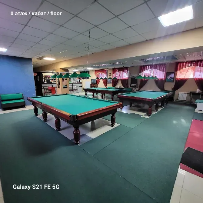 Жасыл үстелдермен бильярд залы