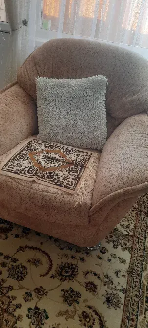 Уютное кресло с подушкой и покрывалом на ковре