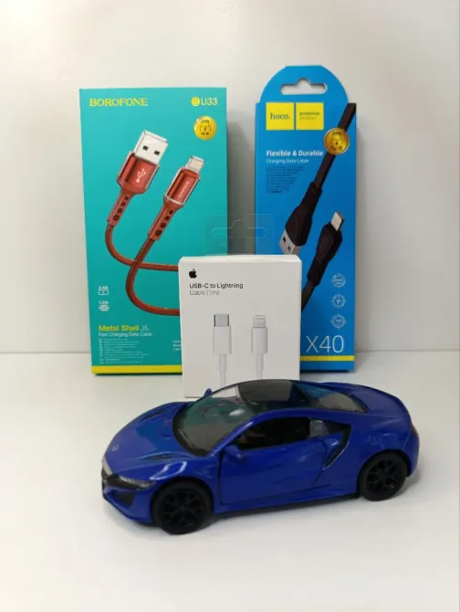 Ақ фондағы USB-кабельдер қаптамалары арасында автокөліктің моделі