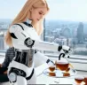 Ұзын жарық шашы бар робот-қызметші, шәйнектен стақандарға шай құйып, терезе арқылы қала көрінісіне қарап тұр.