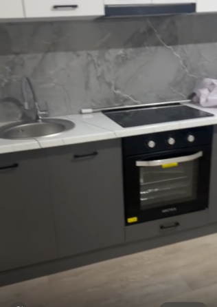 Сұр шкафтары мен мәрмәр қабырға фонындағы плита бары бар асүй