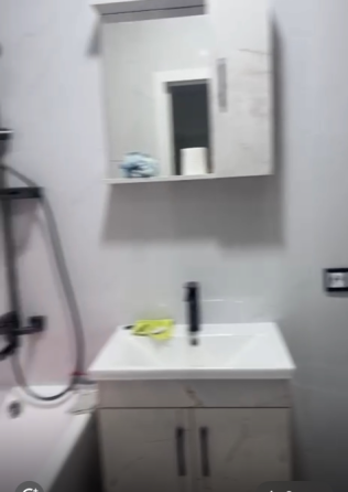 Сұр шкафтары мен мәрмәр қабырға фонындағы плита бары бар асүй