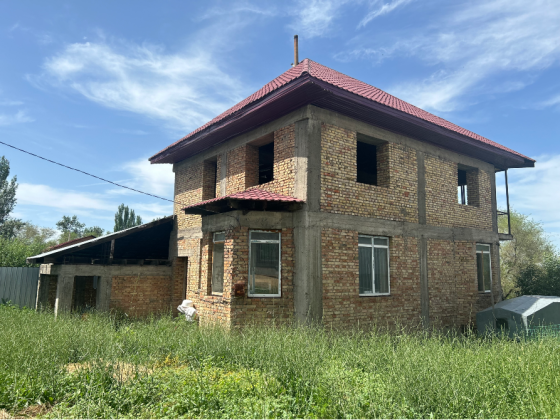 Ескі кірпішті ғимарат қызыл шатырмен және өсімдіктермен жабылған аумақпен