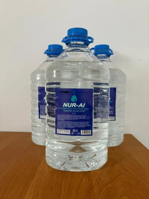 Деревянды бетте орналасқан төрт NUR-AI суы бөтелкесі