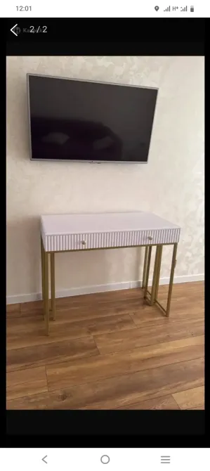 Консольный стол с золотистыми ножками и телевизором на стене