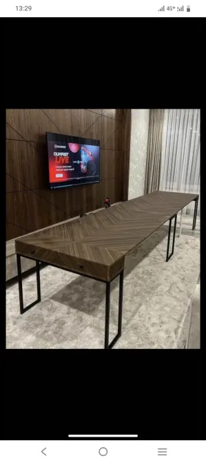 Деревянный стол с металлическими ножками и телевизором на стене