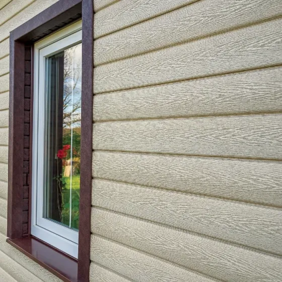 Стена дома, облицованная коричневыми кирпичами с белыми окнами