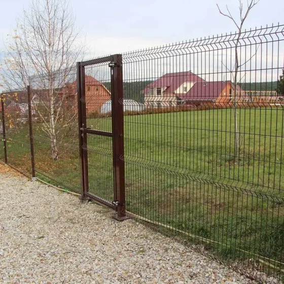 Серая металлическая ограда с вертикальными планками на фоне домов и зелени