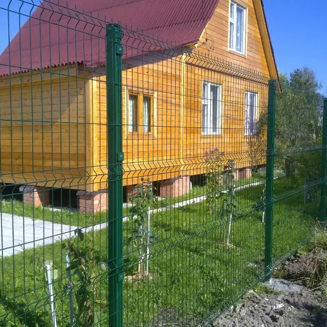 КөGreen сым шарбақ ағаш үй мен бақтың айналасында