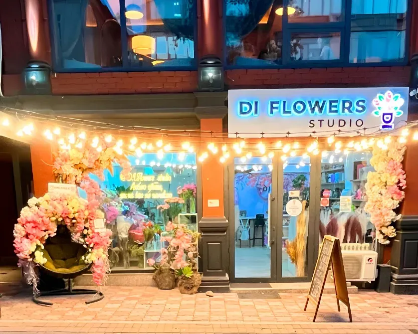 Гүлдер дүкенінің неонды жарнамалары мен гүлдермен безендірілген фасады