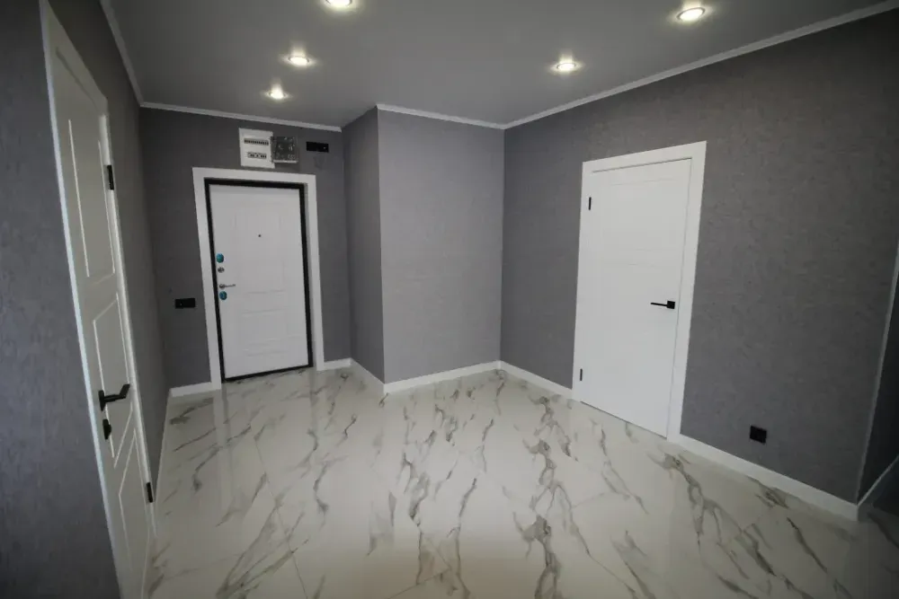 Пустая прихожая с белыми дверями и светлым полом