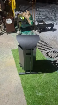 Металдық қоқыс жәшігі жасыл газонда