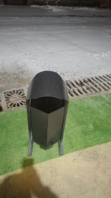 Металдық қоқыс жәшігі жасыл газонда тропинкасымен