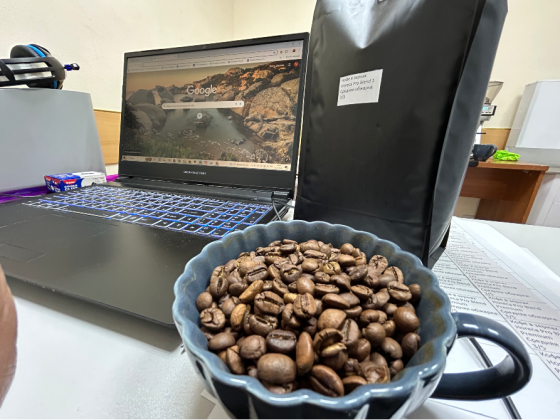 Чаша с жареными кофейными зернами и ноутбук с открытым веб-браузером