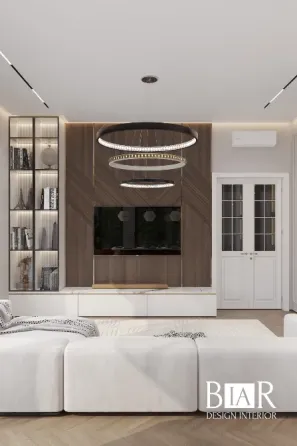 Современный интерьер гостиной с светлыми тонами, элегантной мебелью, стильными подвесными светильниками и телевизором на стене