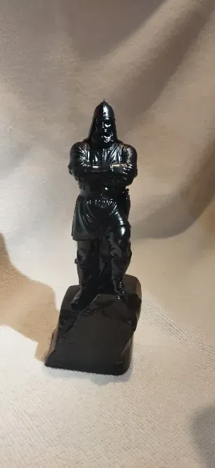 Қара түсті статуэтка, алдыңғы көрініс, жарық фонда