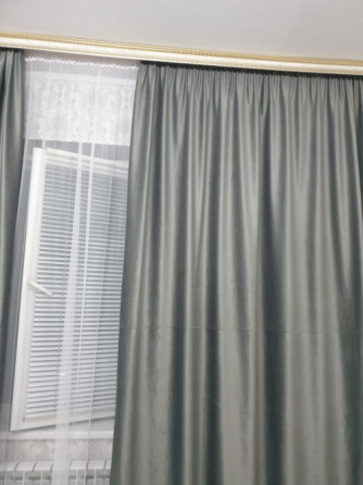 Шторы серого цвета в интерьере комнаты с светлым покрытием пола