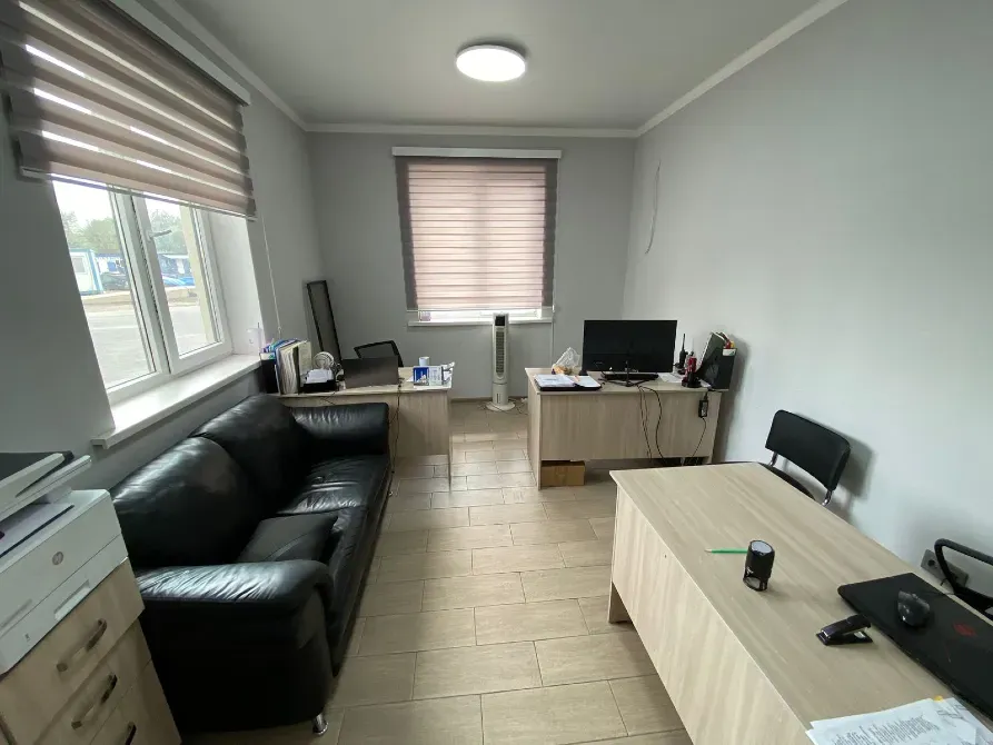 Офисная комната с диваном, столами и компьютером