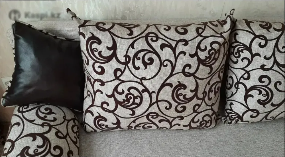 Үзілімді өрнегі бар дивандағы декоративті жастық